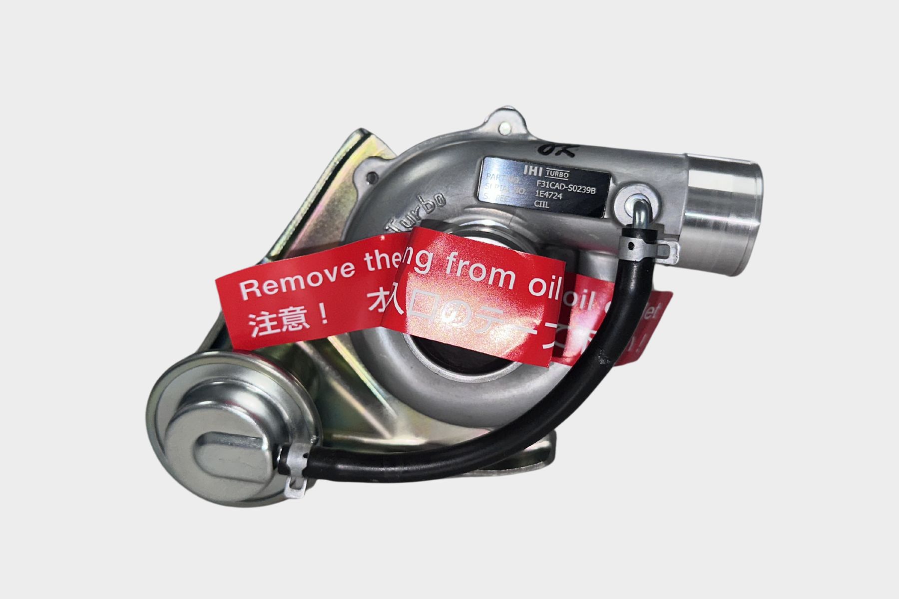 The F31CAD-S0239B IHI Turbocharger CIIL is shown against a plain white background with a red warning tag stating "Remove the tag from oil inlet.