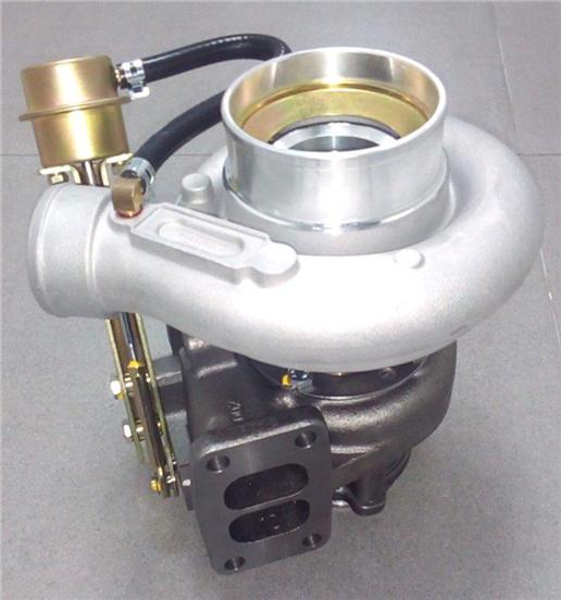 The T4104-01 Zeki Turbocharger HX35W with included gasket is displayed on a gray surface, featuring its metallic compressor and turbine housing assembly with an attached actuator.